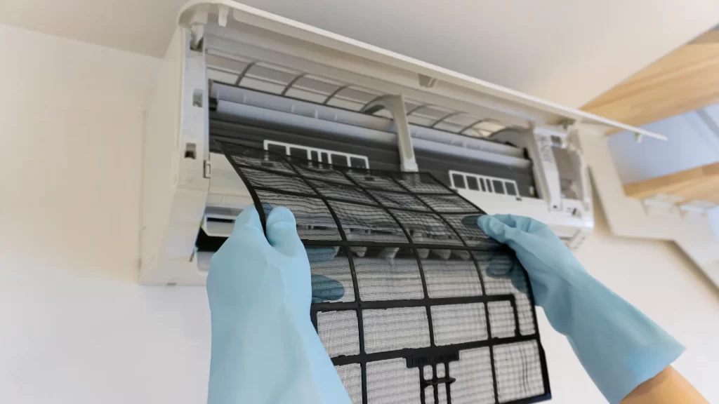 エアコンのフィルターを外し丁寧にクリーニングをする様子