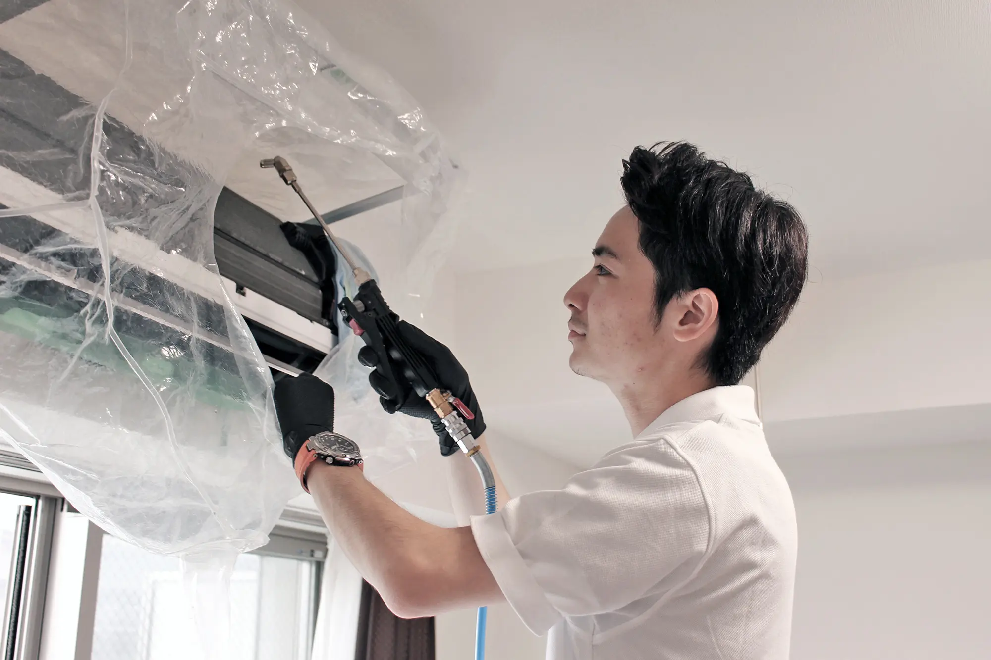 スタッフが専門技術でエアコンクリーニングを行う様子